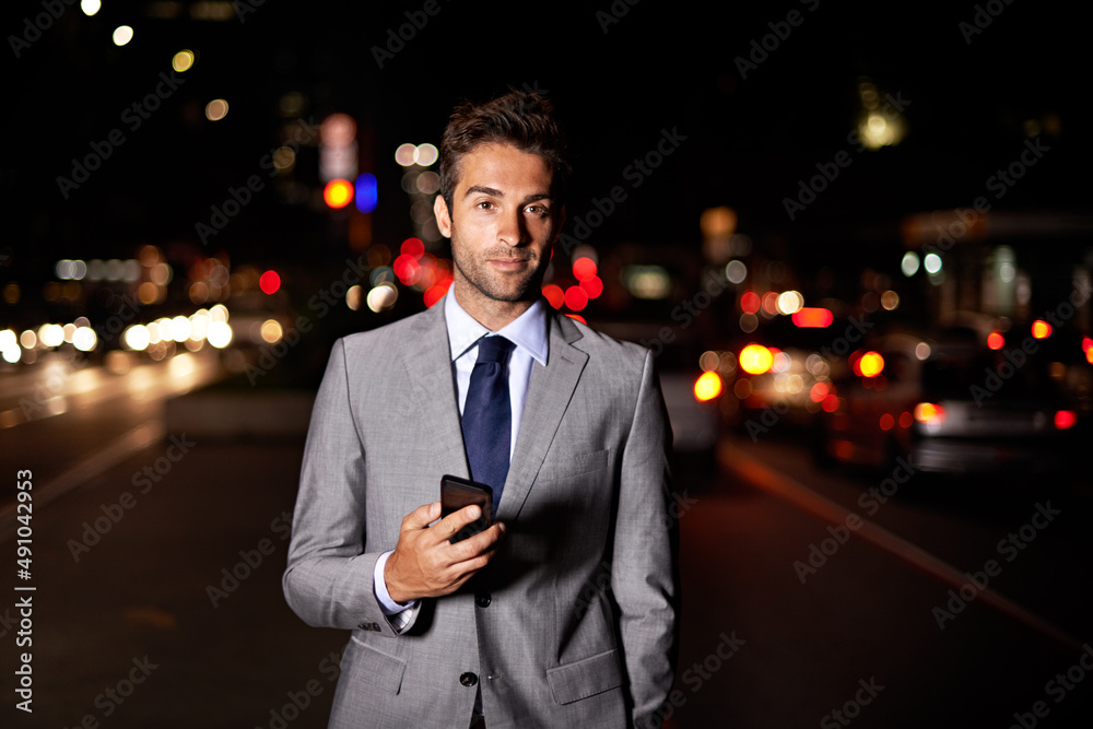 镇上的一个男人。一个英俊的商人站在繁忙的街道上拿着手机的画像