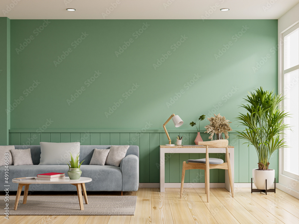 室内实体绿墙，客厅配有蓝色沙发和工作台。
