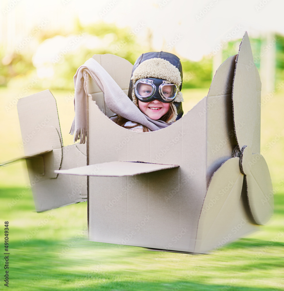 Ready to take to the sky. Portrait of a little boy pretending to fly in a cardboard jet.