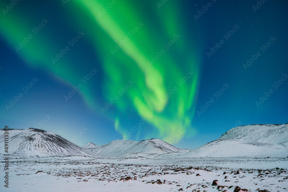 北极光。山脉上空的北极光。冬日夜晚的景色，明亮的灯光