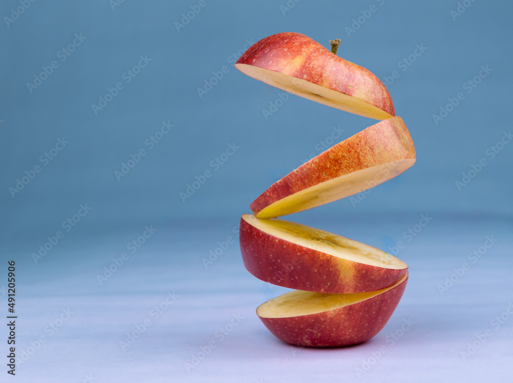 Floating levitating ripe apple on blue background. Vitamins, healthy diet concept. Minimal fruit ide