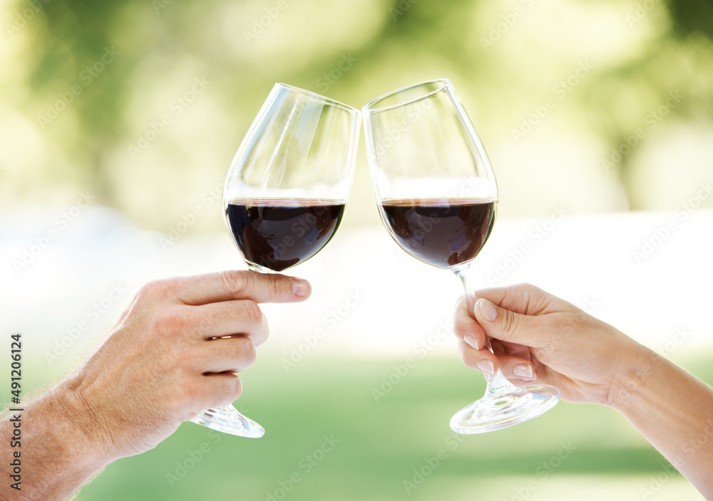 致我们。一对情侣手拿两杯葡萄酒敬酒的裁剪图。