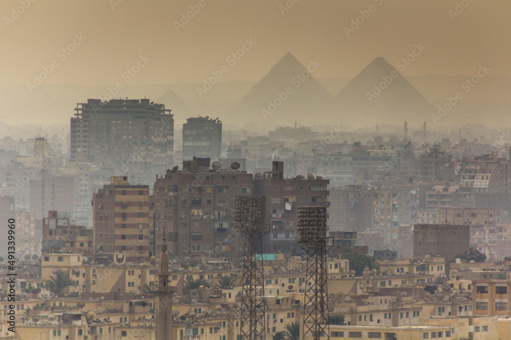 背景是金字塔的开罗薄雾天际线，埃及