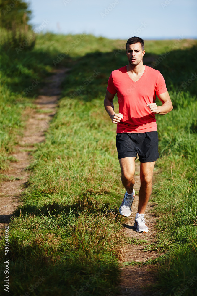 跑步时正确的呼吸很重要。一个英俊的年轻人在户外慢跑的照片。