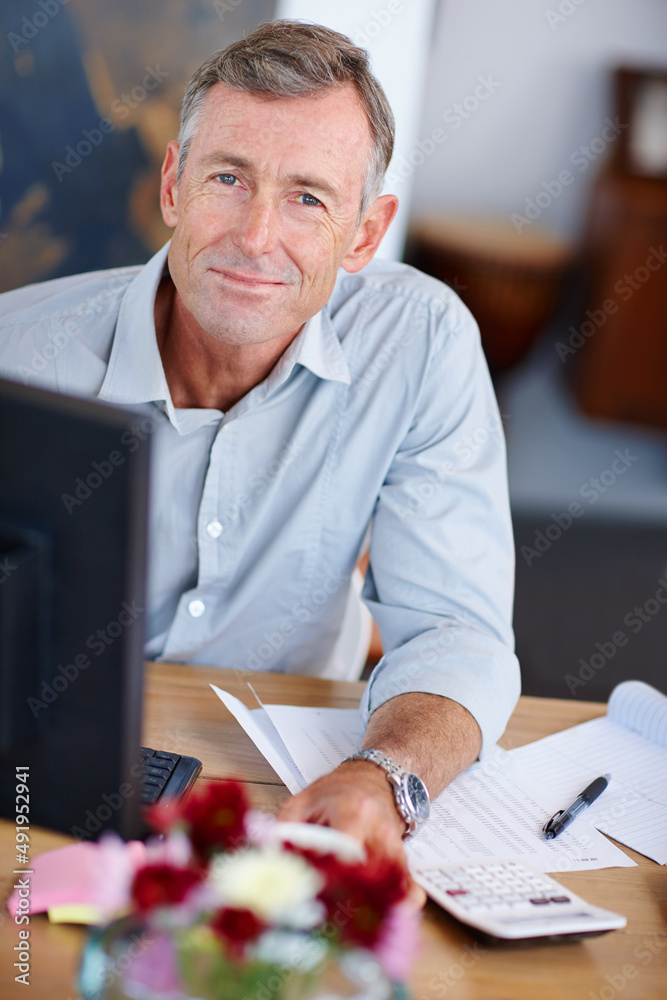 计算他的税收。一个成熟男人坐在家里的电脑前做鳍的肖像