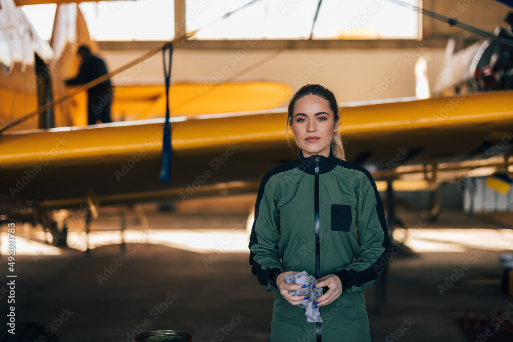 Portrait of a hardworking female pilot finished with polishing her plane.