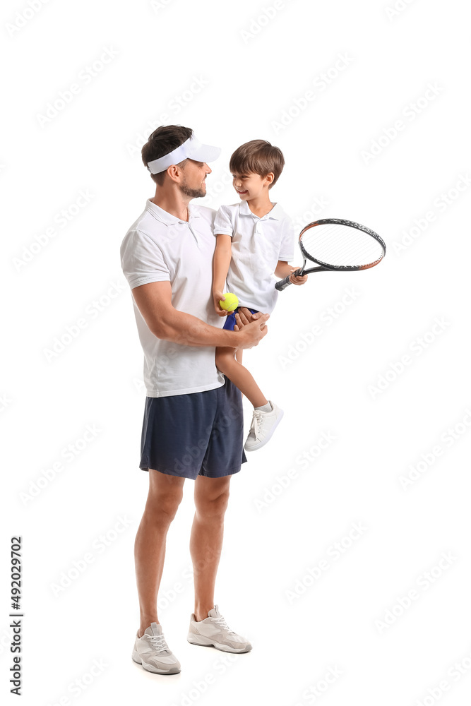 小男孩和他的父亲在白色背景上拿着网球拍和球