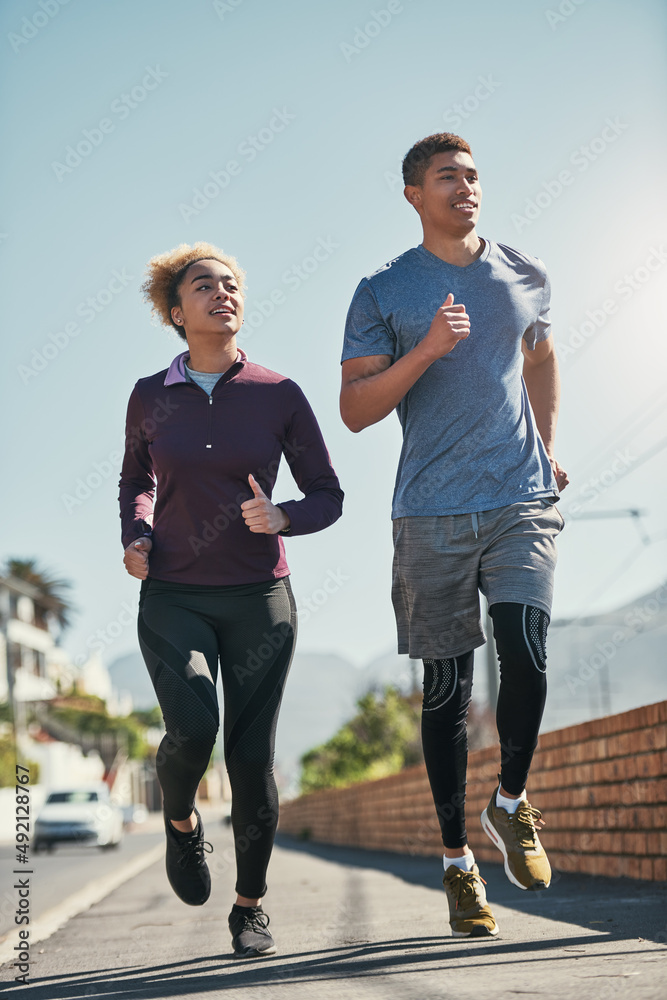 你的健身房就在你的前门外面。一对年轻夫妇一起跑步的照片。