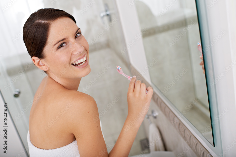 她很注重牙齿卫生。一个漂亮的黑发年轻人早上刷牙。