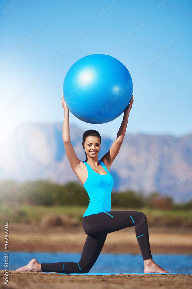 重塑你的身体。一张年轻女子用健身球锻炼的照片。