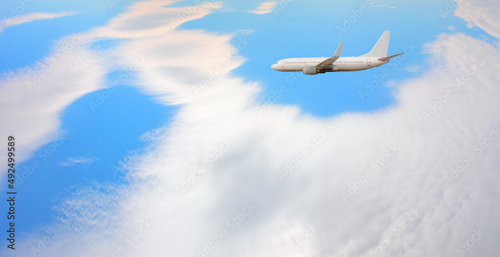 白色客机在天空中飞行，背景是令人惊叹的云朵-乘坐航空运输