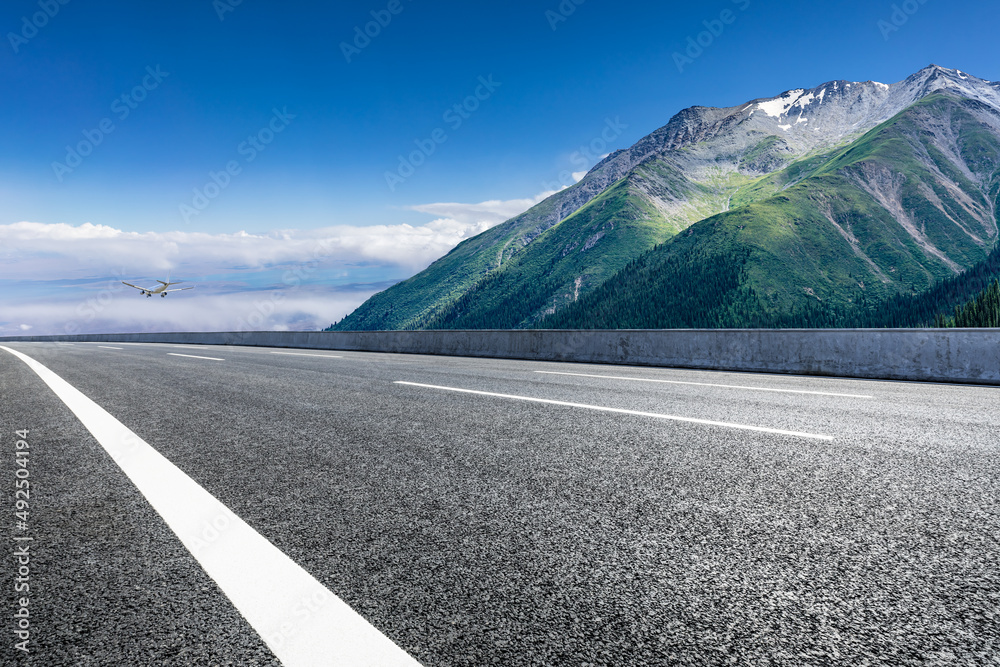 空旷的柏油路和蓝天下的山地自然风光。道路和山脉的背景。