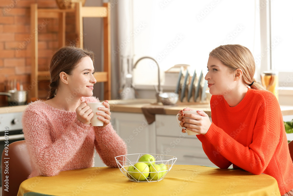 年轻姐妹在家厨房喝茶