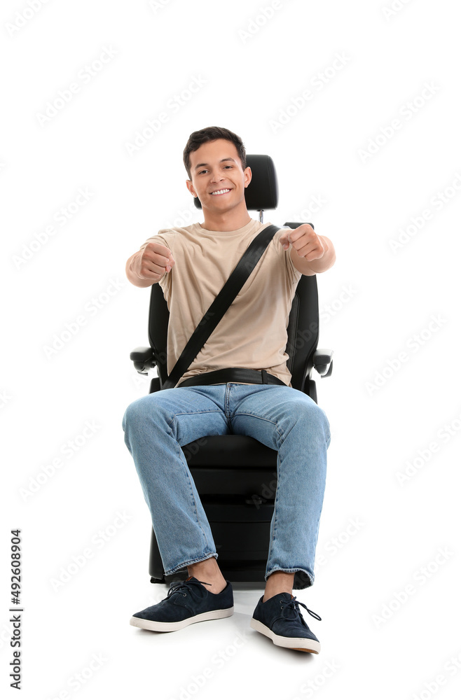 白色背景下，汽车座椅上有一个想象中的方向盘的年轻人