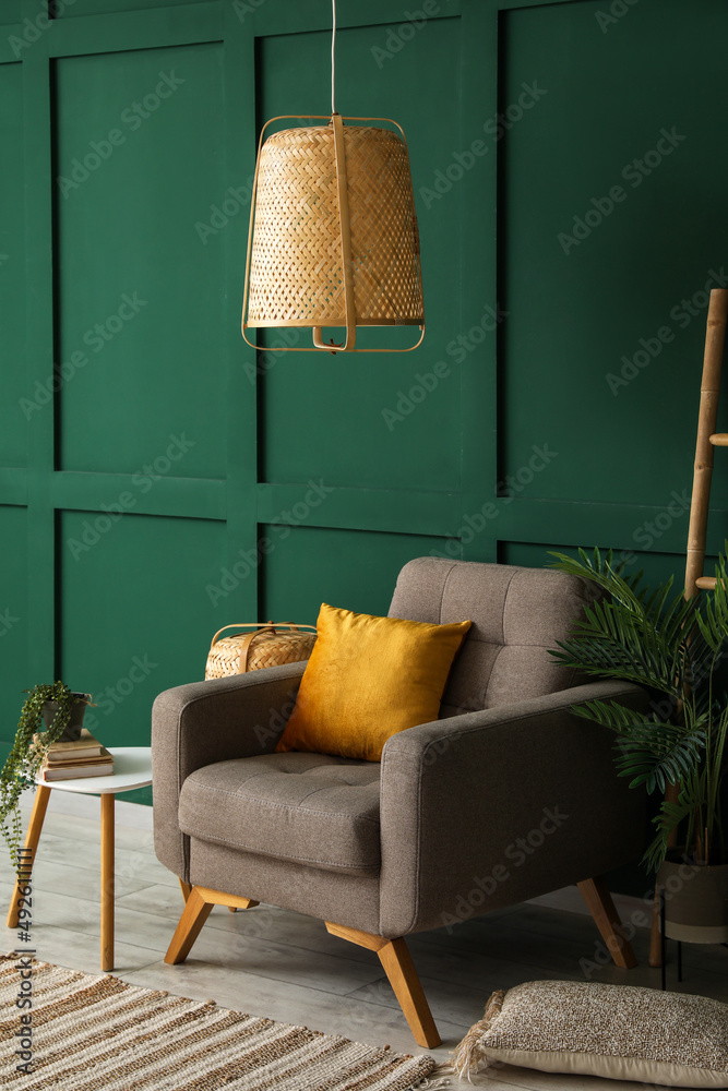 绿色墙壁附近的软扶手椅和吊灯