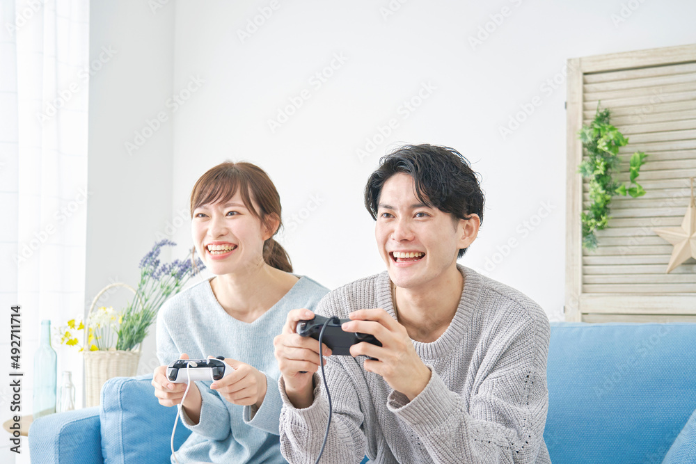 テレビゲームで遊ぶ男女