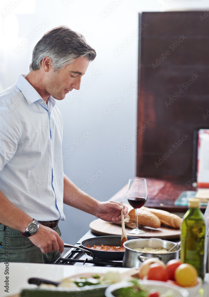 他有一些严肃的厨房技巧。一个成熟男人在厨房做饭的镜头。