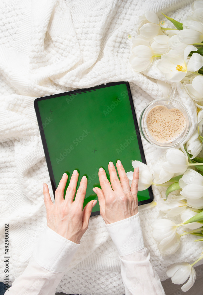 绿屏平板电脑，年轻女性在线寻找母亲节礼物，郁金香