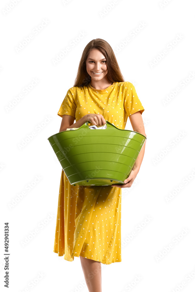 美丽的家庭主妇拿着绿色篮子，白色背景是要洗的衣服