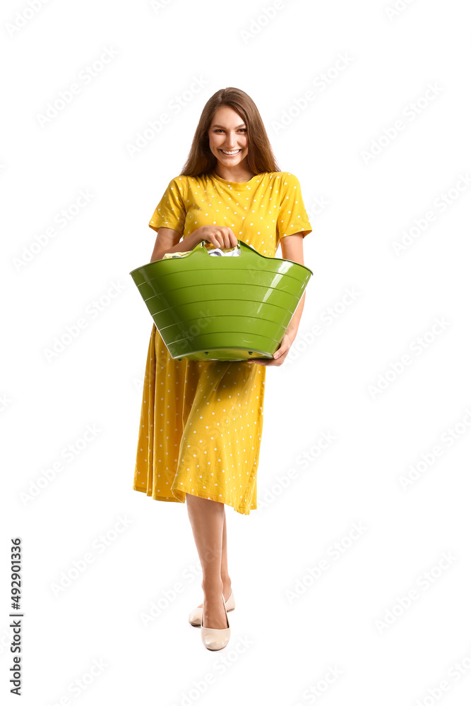 美丽的家庭主妇拿着绿色篮子，白色背景是要洗的衣服