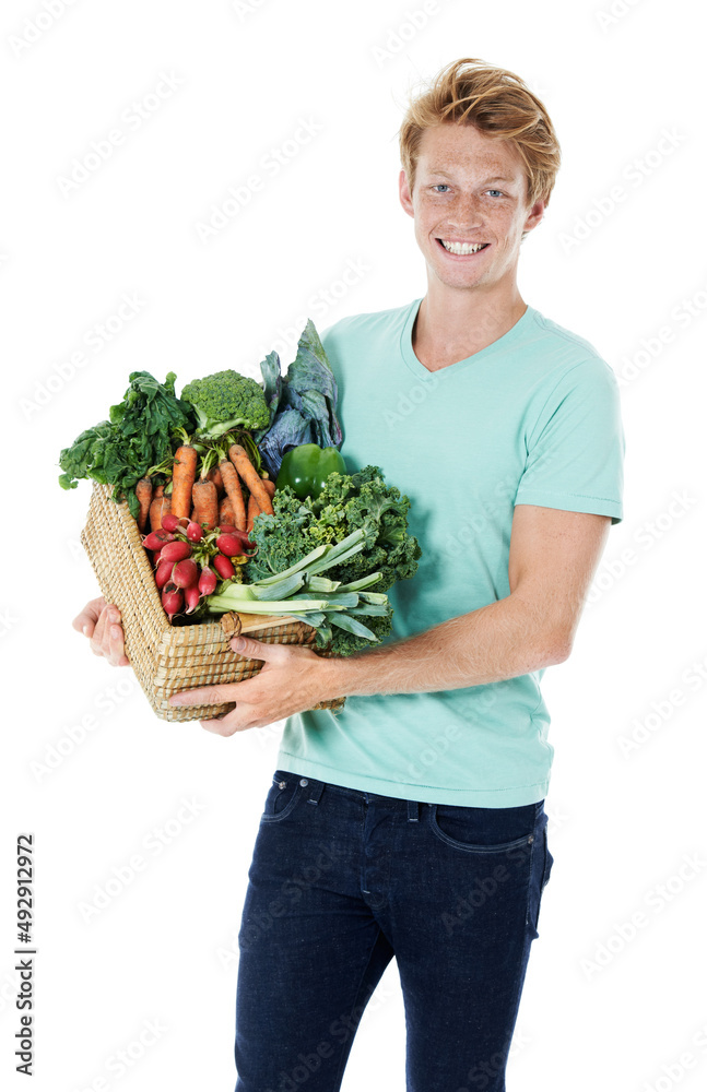 农场里的新鲜蔬菜。一个面带微笑的红头发年轻人拿着装满新鲜有机蔬菜的篮子