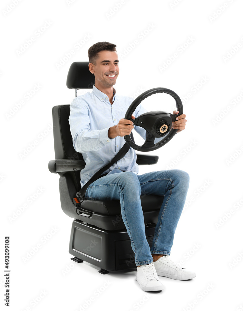 Young man with steering wheel in car seat on white background