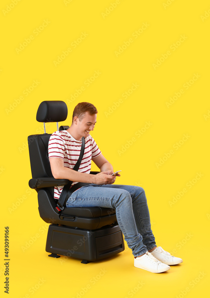 年轻人坐在汽车座椅上，背景是手机