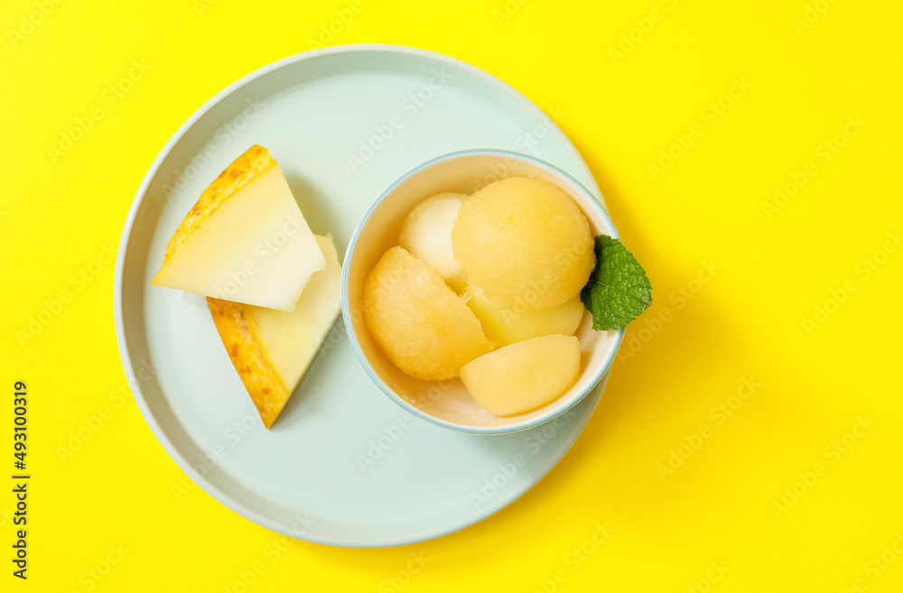 黄色背景上有美味的冰糕和甜瓜块的碗
