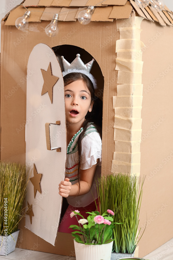 有趣的小女孩在家玩纸板屋