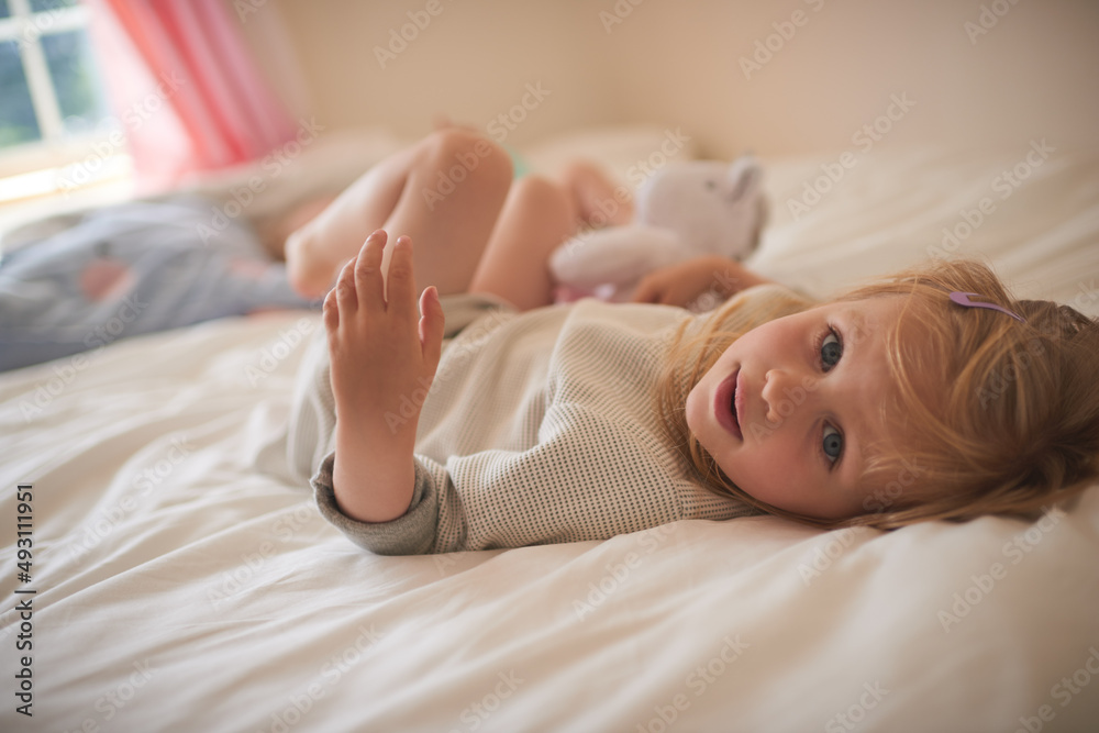 来自一个小女孩的甜蜜。一个可爱的小女孩在h的床上放松的肖像