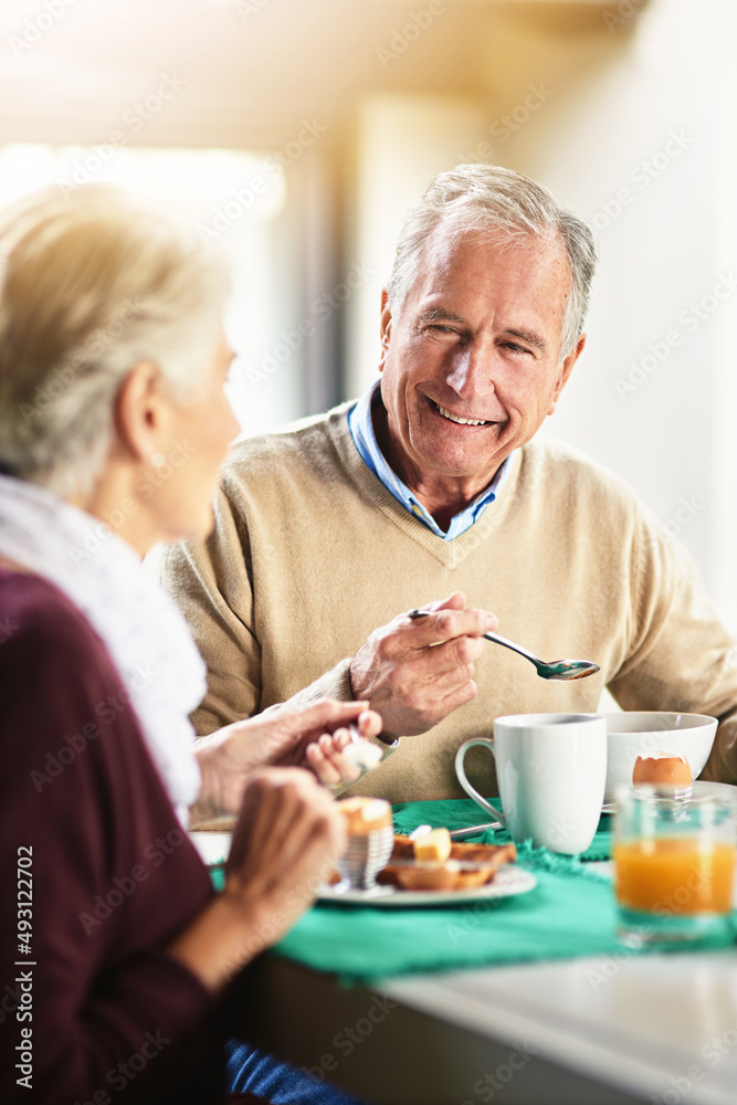 所有的幸福都取决于悠闲的早餐。一对幸福的老年夫妇享受早餐的照片