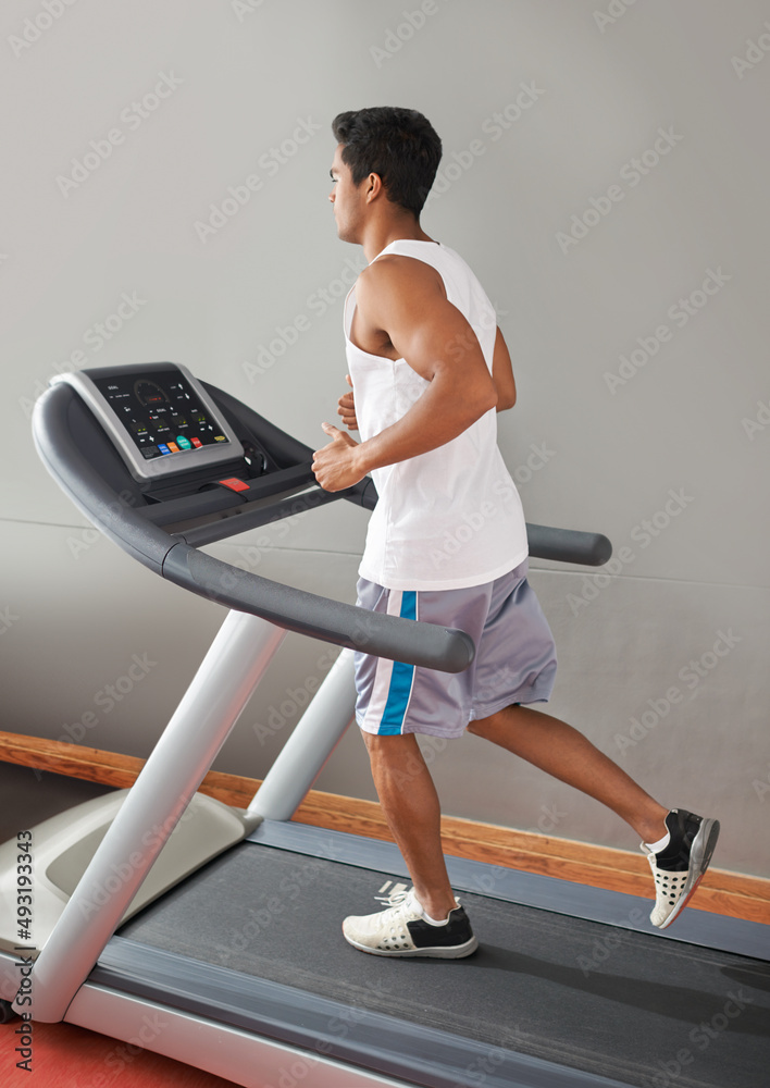 心脏也需要锻炼。一个年轻的少数民族男子在跑步机上跑步。