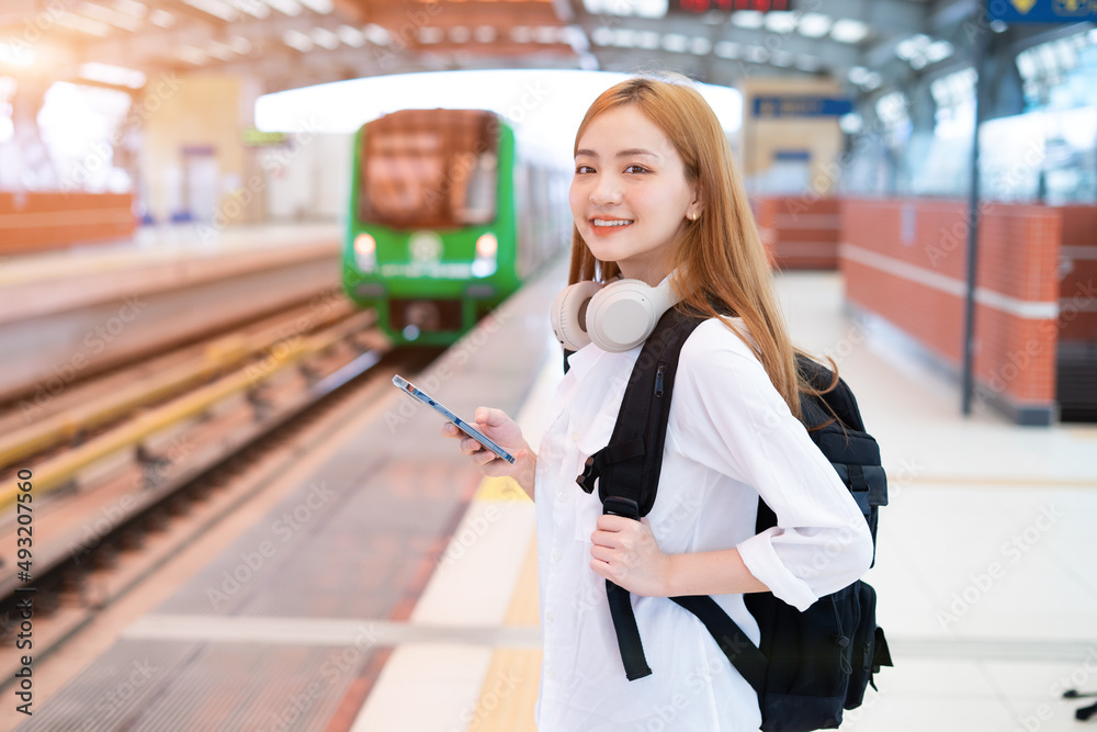 年轻的亚洲女孩在车站等火车