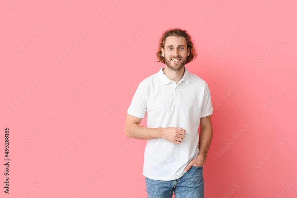 身穿粉色背景时尚马球衫的英俊年轻人