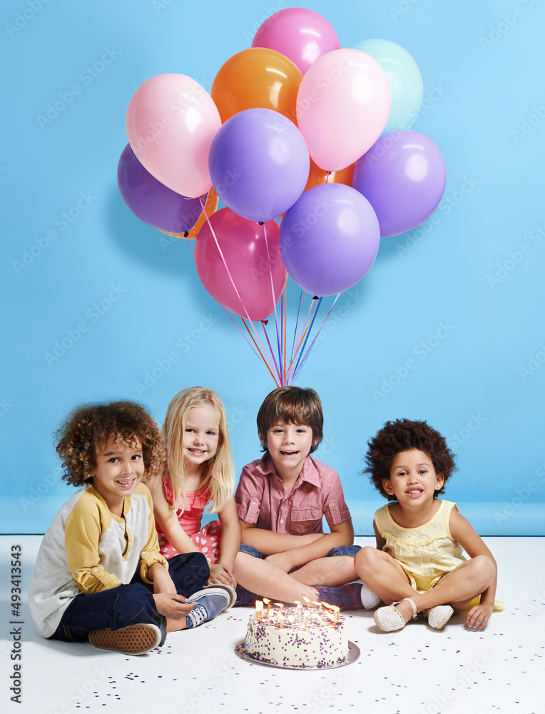我的生日愿望是永远成为朋友。一群孩子坐在生日蛋糕周围的照片
