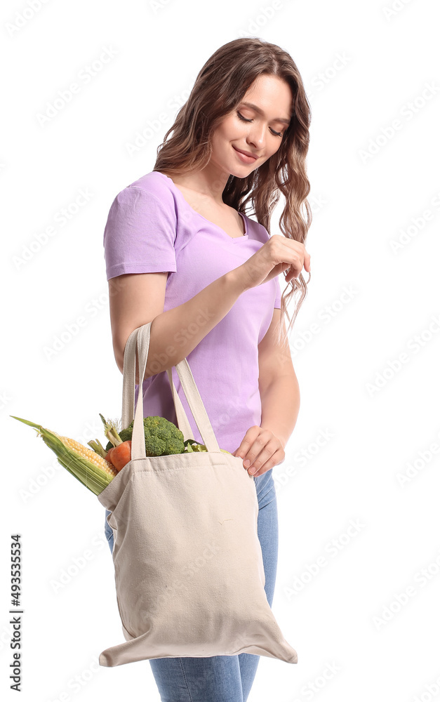 年轻女子拿着环保袋，白色背景是新鲜蔬菜