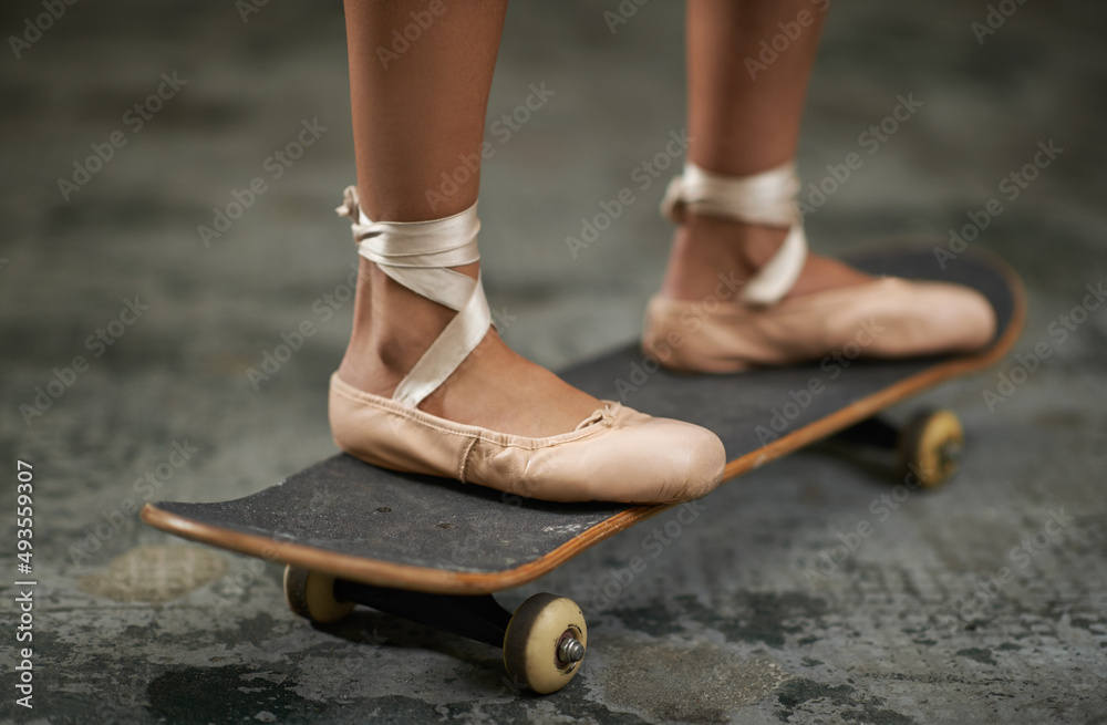 车轮上的优雅。一个穿着芭蕾舞拖鞋的女人在滑板上的裁剪图。