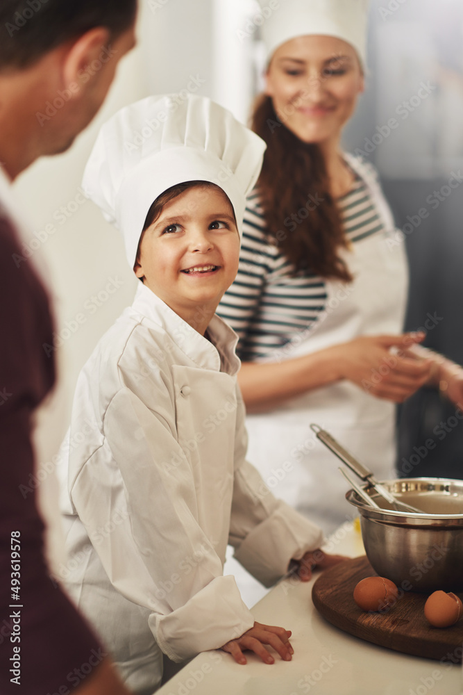 正在烘焙。一个微笑的家庭在厨房里一起烘焙的镜头。