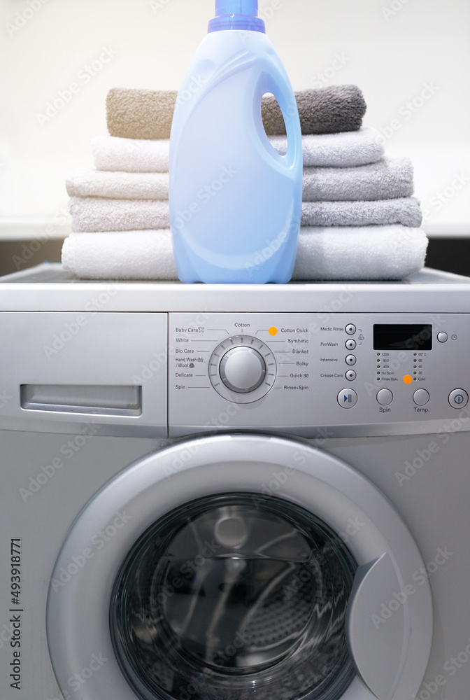你的洗衣房会喜欢的。一张洗衣机的照片，上面有折叠的毛巾和洗涤剂。