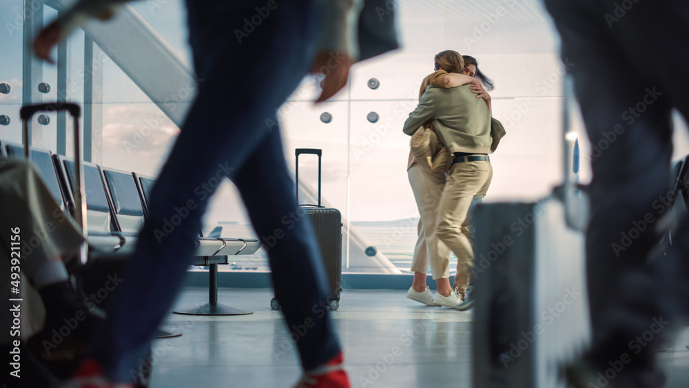 机场航站楼家庭团聚：美丽的情侣在登机休息室相遇。微笑的女孩拥抱我