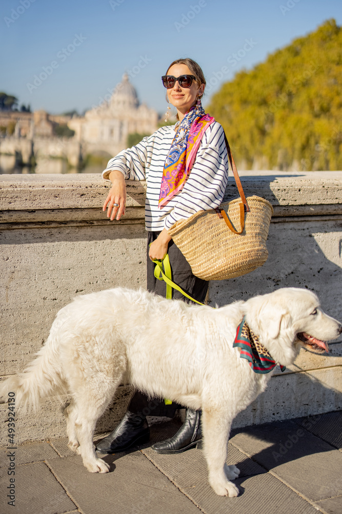 带着狗的女人在桥上，可以看到罗马城的风景。带着她的崇拜者的时尚高加索女人