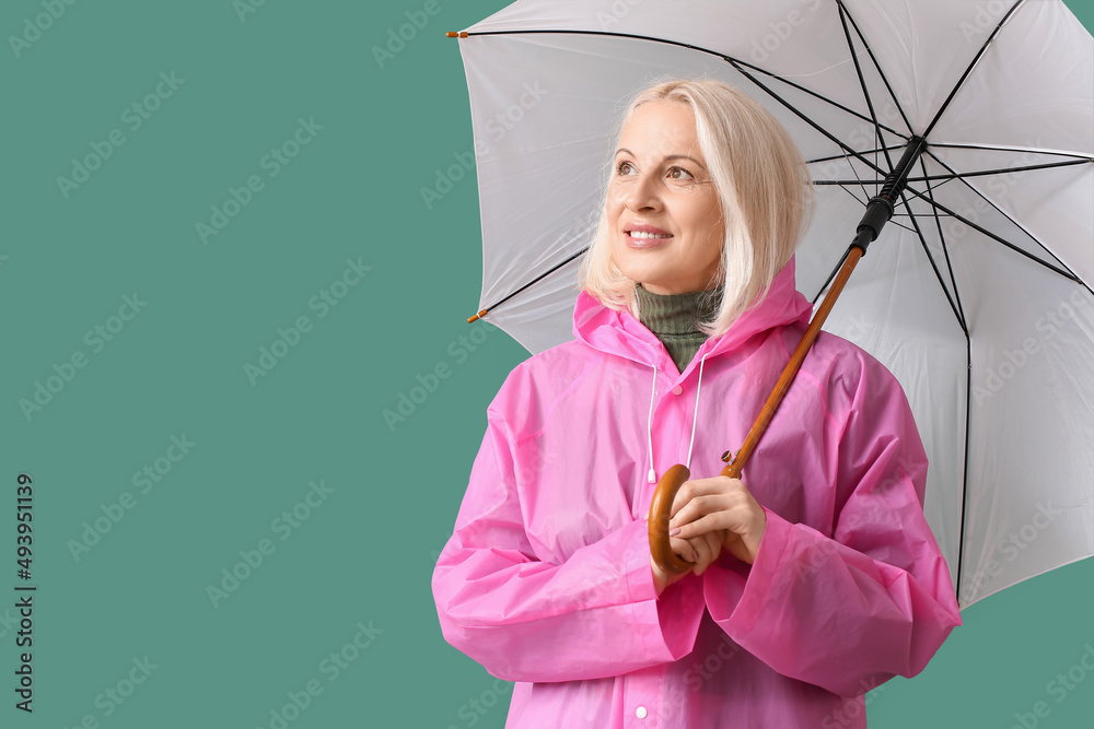 美丽的成熟女人，穿着雨衣，彩色背景带伞