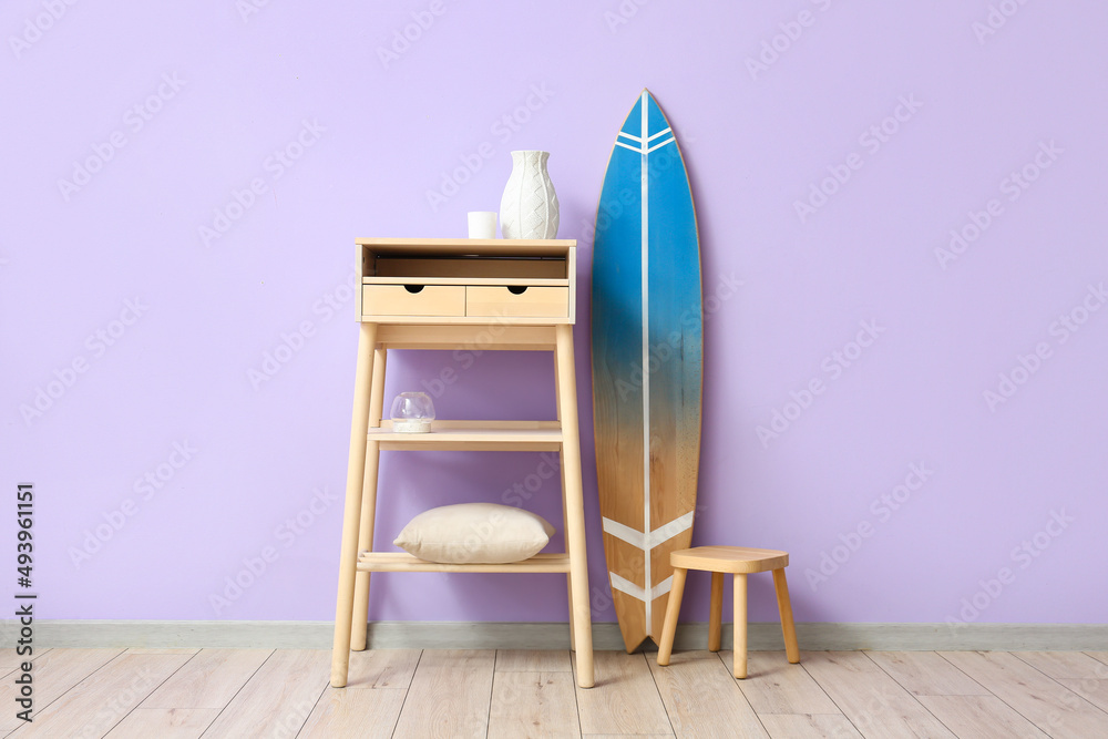 靠近彩色墙的冲浪板、桌子和凳子