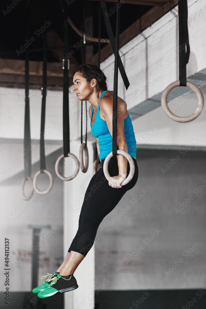 在吊环上。一名年轻女子在体操吊环上锻炼的全镜头。