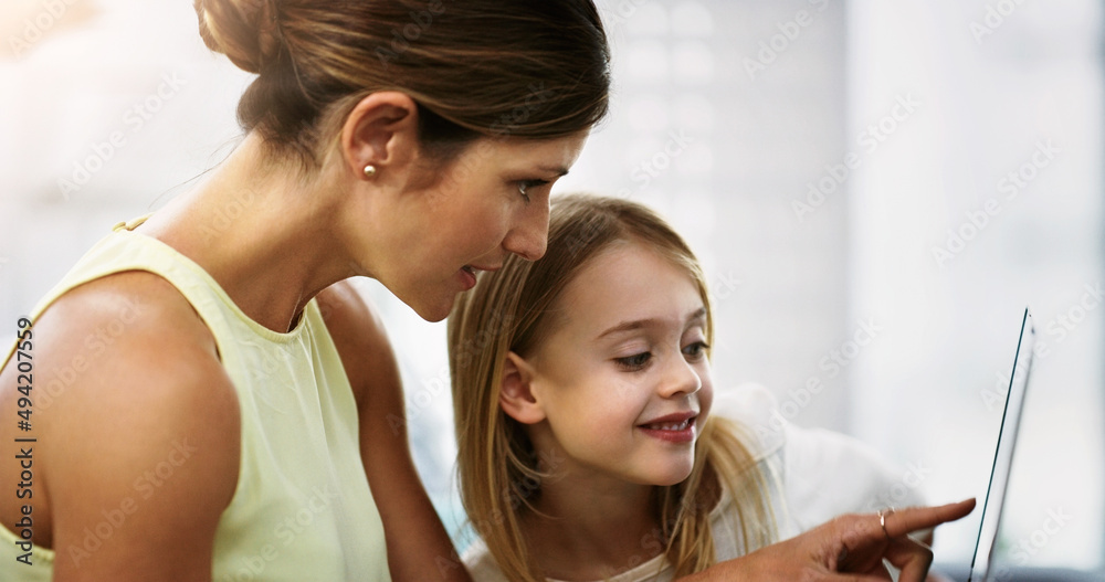 Showing her how to navigate through the app world. Shot of a beautiful young mother and her daughter