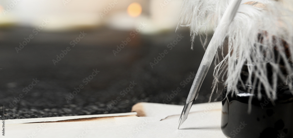 羽毛笔、纸张和墨水池放在桌子上，特写