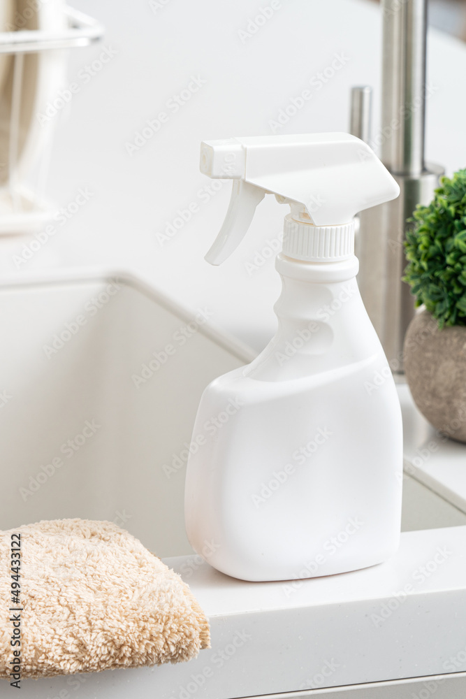 现代厨房水槽旁的清洁产品喷雾瓶。