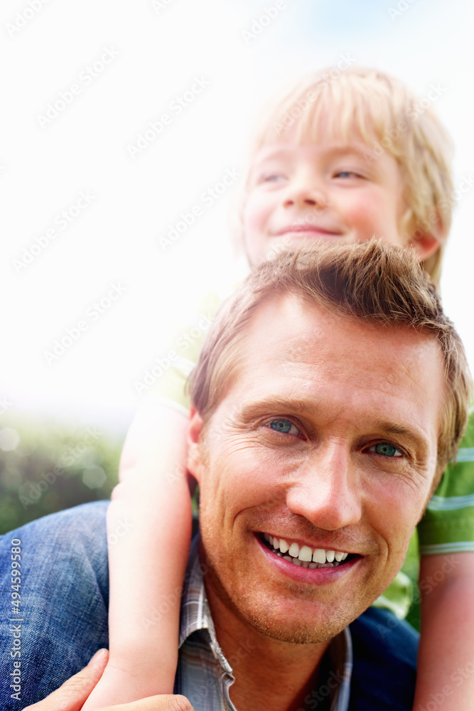 微笑的成熟男人骑着他的儿子。微笑的成熟男子打招呼的特写