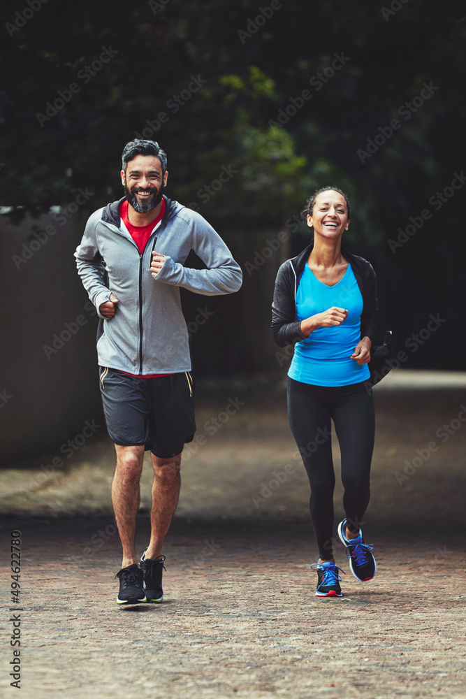 离开健身房，到户外锻炼。一对情侣一起跑步的照片。