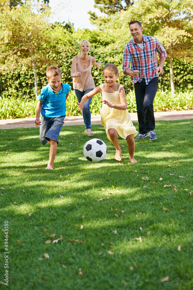 在公园里玩得很开心。在一个美丽的夏天，一家人在公园里踢足球。